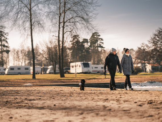 Ett par som promenerar pa en strand pa hosten.