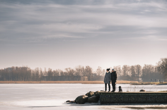 Två personer som står vid havet